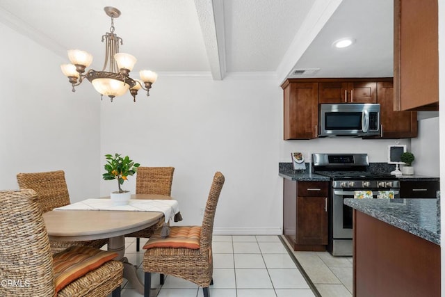 kitchen with stainless steel appliances, a chandelier, light tile patterned floors, ornamental molding, and hanging light fixtures