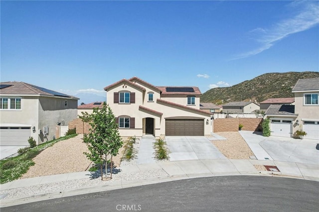 29586 Bisbee Ct, Winchester, CA 92596 - view of front of property featuring roof mounted solar panels, driveway, stucco siding, a mountain view, and an attached garage