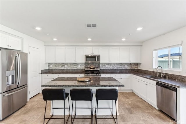 29586 Bisbee Ct, Winchester, CA 92596 - kitchen featuring appliances with stainless steel finishes, a sink, a breakfast bar area, a center island, and decorative backsplash
