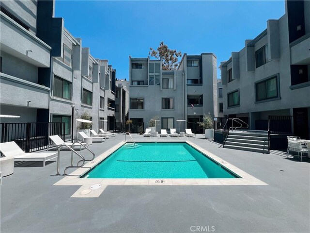 community pool with a patio and a residential view