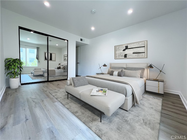 bedroom with wood finished floors, recessed lighting, and baseboards