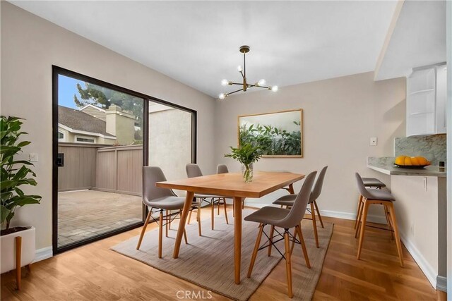 401 Deerfield Ave Unit 84, Irvine, CA 92606 - dining area featuring a chandelier, baseboards, and light wood-style flooring