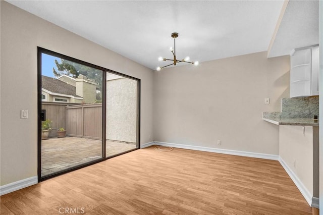 401 Deerfield Ave Unit 84, Irvine, CA 92606 - unfurnished dining area with a chandelier, wood finished floors, and baseboards