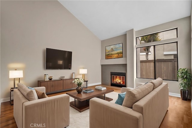 401 Deerfield Ave Unit 84, Irvine, CA 92606 - living area with wood finished floors, baseboards, high vaulted ceiling, and a glass covered fireplace
