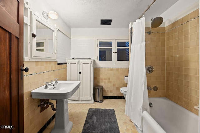 657 Prospect Blvd, Pasadena, CA 91103 - full bathroom featuring tile walls, toilet, shower / bath combination with curtain, tile patterned floors, and a textured ceiling