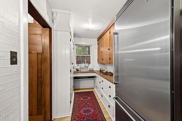 657 Prospect Blvd, Pasadena, CA 91103 - kitchen with high quality fridge, light wood finished floors, and white cabinetry