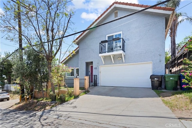 9319 Rowell Ave, Chatsworth, CA 91311 - view of front of property featuring a balcony, stucco siding, an attached garage, concrete driveway, and fence