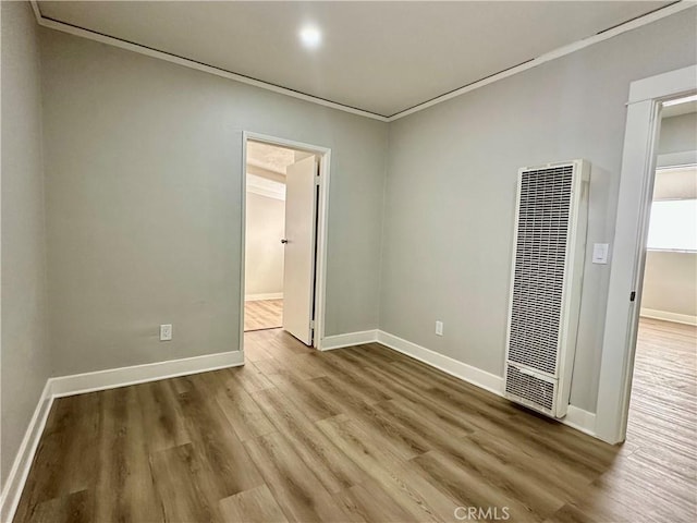 1516 W Burnett St, Long Beach, CA 90810 - spare room with a heating unit, wood finished floors, crown molding, and baseboards