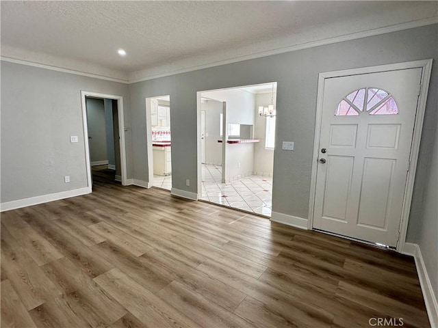 1516 W Burnett St, Long Beach, CA 90810 - foyer entrance with ornamental molding, a chandelier, a textured ceiling, wood finished floors, and baseboards