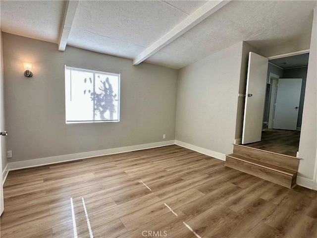 1516 W Burnett St, Long Beach, CA 90810 - spare room featuring beamed ceiling, a textured ceiling, light wood-type flooring, and baseboards
