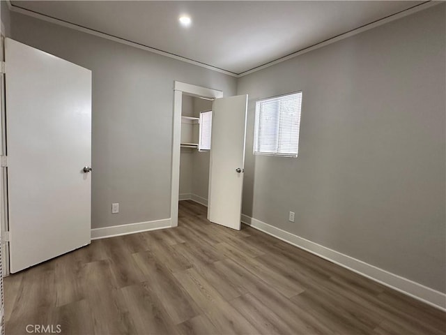 1516 W Burnett St, Long Beach, CA 90810 - unfurnished bedroom with baseboards, wood finished floors, a spacious closet, ornamental molding, and a closet
