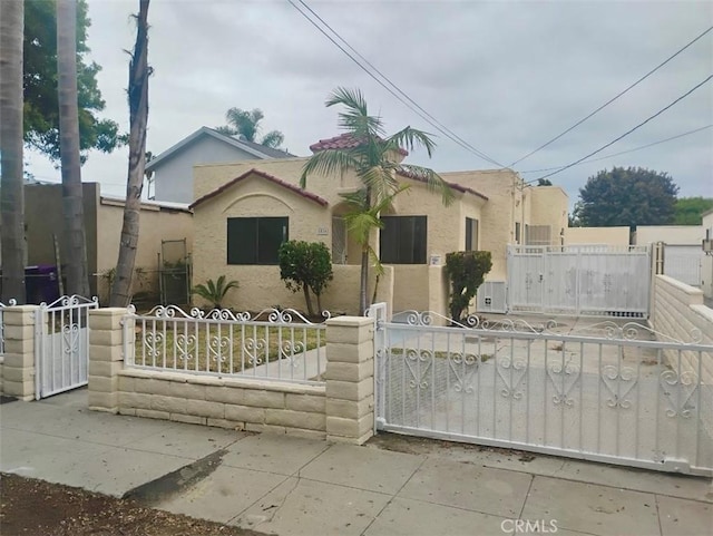 1516 W Burnett St, Long Beach, CA 90810 - mediterranean / spanish-style house featuring a gate, stucco siding, and a fenced front yard