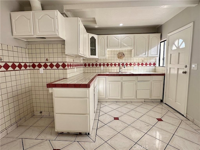 1516 W Burnett St, Long Beach, CA 90810 - kitchen featuring a sink, tile countertops, light tile patterned floors, and white cabinetry