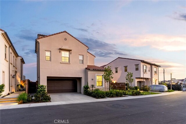 214 Canterbury, Irvine, CA 92618 - view of front facade featuring an attached garage, a tile roof, stucco siding, and driveway