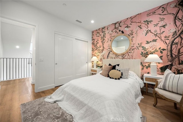 214 Canterbury, Irvine, CA 92618 - bedroom featuring wallpapered walls, an accent wall, light wood-style flooring, a closet, and baseboards