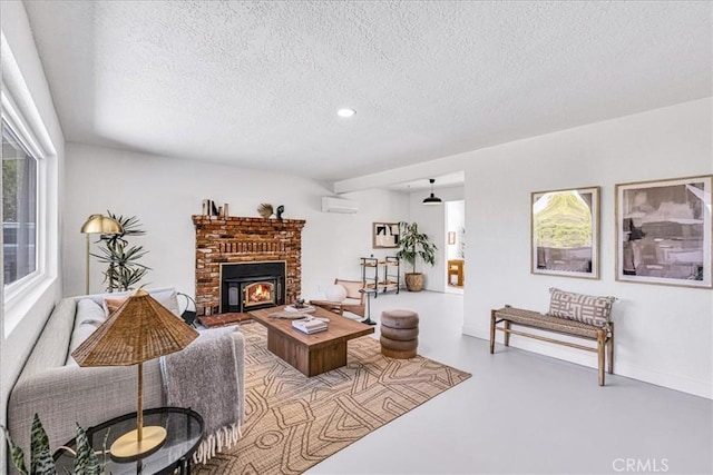 living area featuring a wall unit AC, a textured ceiling, finished concrete flooring, a fireplace, and recessed lighting