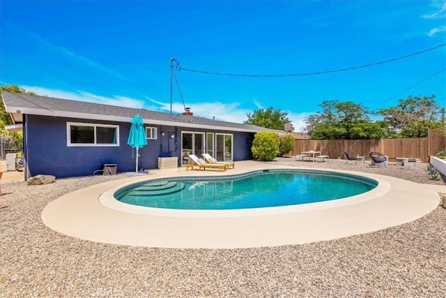 view of swimming pool with a patio area, fence, and an outdoor fire pit