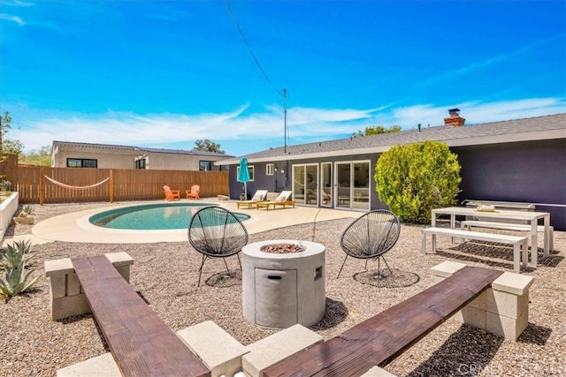 view of pool with an outdoor fire pit, a patio, and a fenced backyard