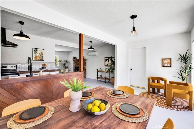 dining area featuring a textured ceiling and a wall unit AC