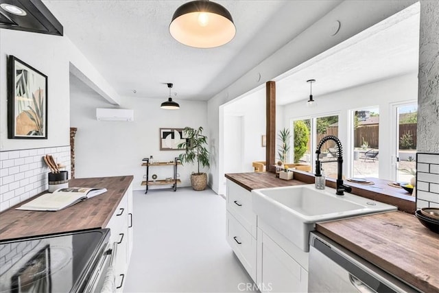 kitchen featuring butcher block counters, stainless steel appliances, a sink, and decorative backsplash