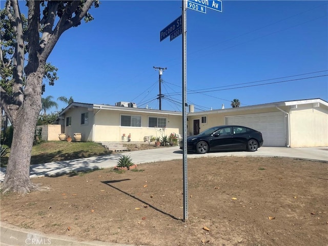 903 Lacon Ave, La Puente, CA 91744 - view of front of house with stucco siding, driveway, and a garage