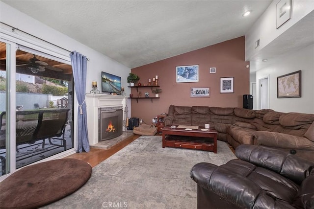 26731 Sinforosa Dr, Mission Viejo, CA 92691 - living area featuring vaulted ceiling, wood finished floors, a warm lit fireplace, and a ceiling fan