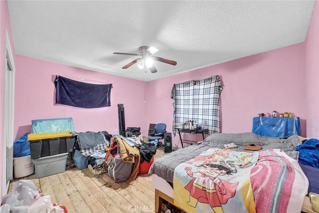 bedroom featuring hardwood / wood-style flooring, a textured ceiling, and ceiling fan