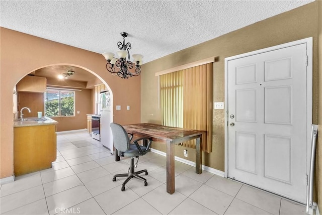 office space featuring arched walkways, a chandelier, baseboards, light tile patterned floors, and a textured ceiling
