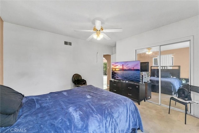 bedroom with light colored carpet, ceiling fan, and a closet