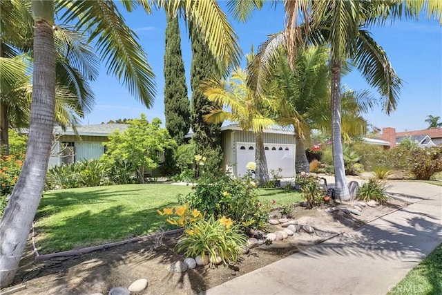 view of property hidden behind natural elements featuring a front yard and a garage