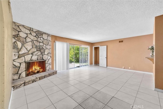 unfurnished living room featuring a textured ceiling, a fireplace, tile patterned floors, and baseboards