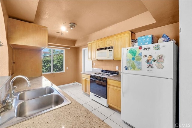 kitchen featuring white appliances, a sink, light brown cabinetry, light tile patterned flooring, and light countertops