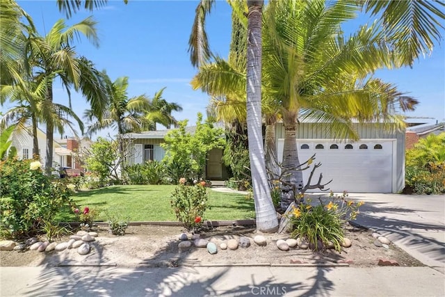 view of property hidden behind natural elements featuring driveway, a front yard, and a garage