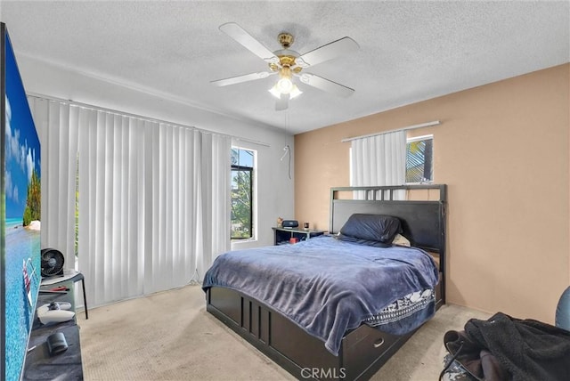 bedroom with carpet floors, a textured ceiling, and a ceiling fan