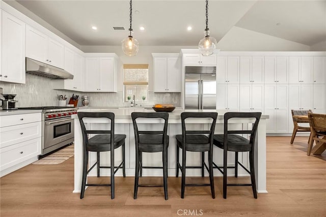 109 Fairgreen, Irvine, CA 92618 - kitchen featuring high quality appliances, under cabinet range hood, a sink, a breakfast bar, and white cabinetry
