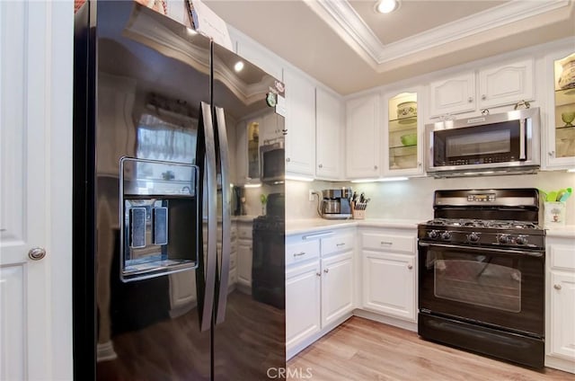 8646 Butte Cir Unit 604B, Huntington Beach, CA 92646 - kitchen with stainless steel appliances, ornamental molding, light countertops, a tray ceiling, and white cabinets