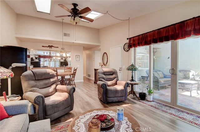 8646 Butte Cir Unit 604B, Huntington Beach, CA 92646 - living room featuring light wood finished floors, a ceiling fan, baseboards, and a high ceiling
