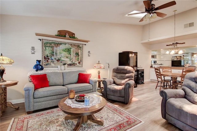 8646 Butte Cir Unit 604B, Huntington Beach, CA 92646 - living area with a ceiling fan, light wood-type flooring, a chandelier, and baseboards
