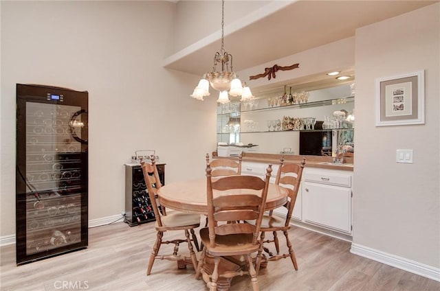 8646 Butte Cir Unit 604B, Huntington Beach, CA 92646 - dining space featuring a chandelier, light wood-type flooring, and baseboards