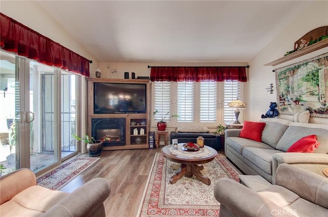 8646 Butte Cir Unit 604B, Huntington Beach, CA 92646 - living area with lofted ceiling, wood finished floors, and a glass covered fireplace