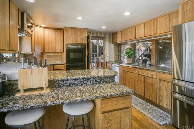 15390 Las Planideras, Rancho Santa Fe, CA 92067 - kitchen with appliances with stainless steel finishes, a sink, dark stone counters, wood finished floors, and recessed lighting