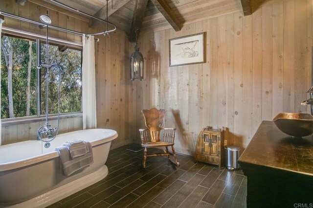 15390 Las Planideras, Rancho Santa Fe, CA 92067 - bathroom featuring beamed ceiling, wood ceiling, wood walls, a freestanding bath, and healthy amount of natural light