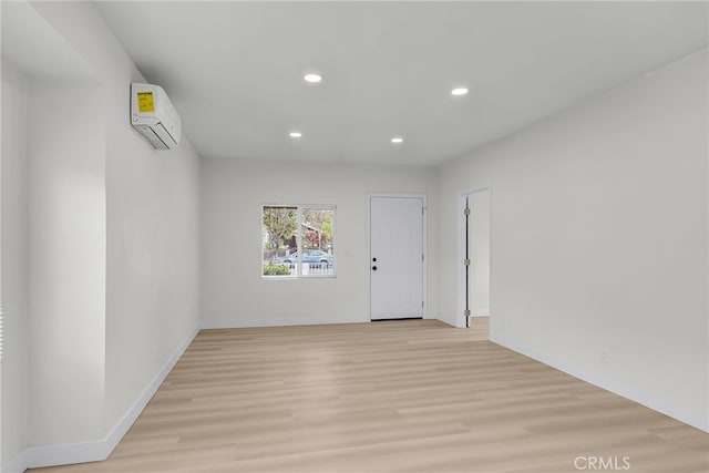 970 E 6th St, Pomona, CA 91766 - unfurnished room with a wall mounted air conditioner, recessed lighting, light wood-style flooring, and baseboards
