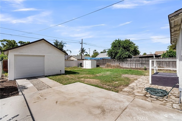 970 E 6th St, Pomona, CA 91766 - view of yard featuring an outdoor structure, a detached garage, driveway, and a patio