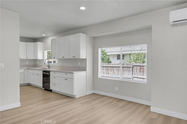 970 E 6th St, Pomona, CA 91766 - kitchen featuring dishwasher, light wood-style floors, baseboards, light countertops, and a wall unit AC