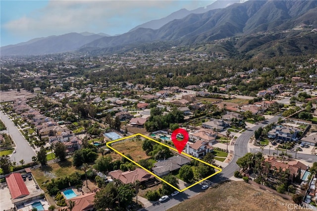 aerial perspective of suburban area with property parcel outlined and a mountainous background