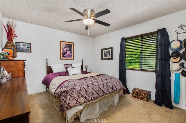 carpeted bedroom featuring a textured ceiling and ceiling fan
