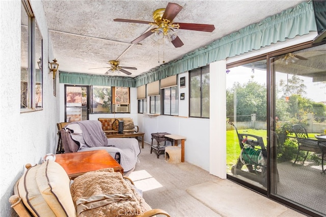 sunroom / solarium featuring a ceiling fan, carpet floors, and a textured ceiling