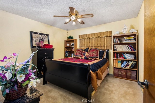 carpeted bedroom featuring a textured ceiling and ceiling fan