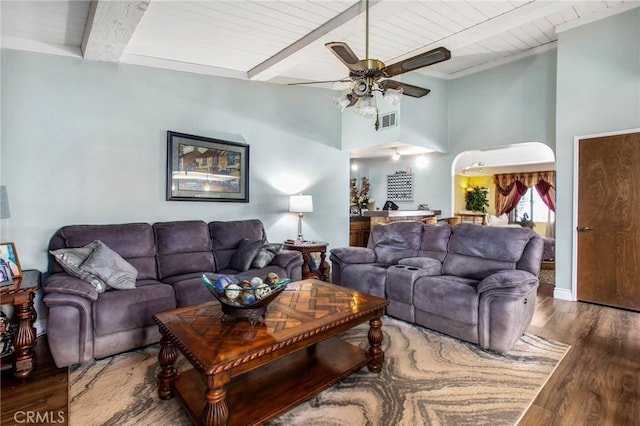 living room featuring ceiling fan, wood finished floors, beamed ceiling, wooden ceiling, and high vaulted ceiling